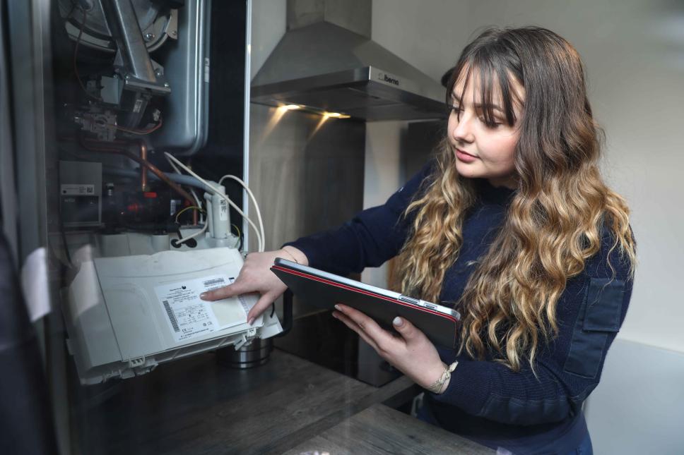 Identification modele de chaudière par une technicienne gaz dans une cuisine